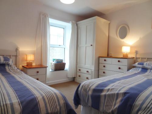 ウェイドブリッジにあるKingfisher Cottageのベッドルーム1室(ベッド2台、窓付)