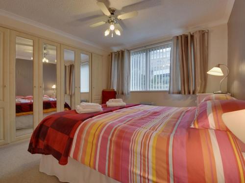 KingsandにあるApartment 66のベッドルーム1室(カラフルなストライプ毛布付きのベッド1台付)