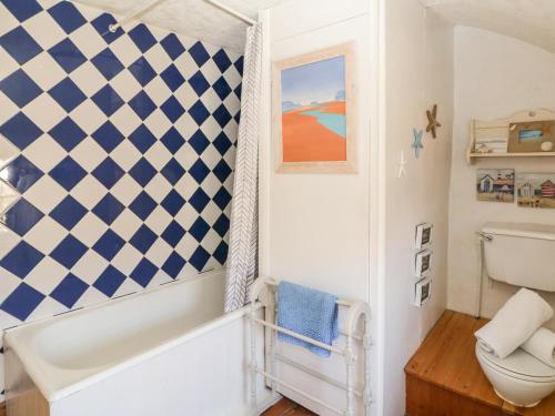 ein Bad mit einer blau-weißen, karierten Wand in der Unterkunft Uphill Cottage in Saint Ervan