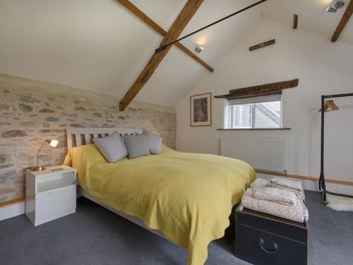 a bedroom with a large bed and a stone wall at Salty Cottage in Morwenstow