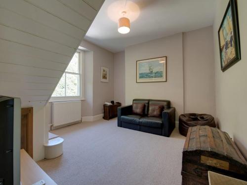 ein Wohnzimmer mit einem Sofa und einem Stuhl in der Unterkunft The Captains House in Downderry