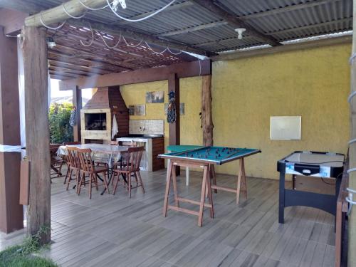 una terraza con mesa de ping pong y parrilla en Pousada Don Fernandes en Torres