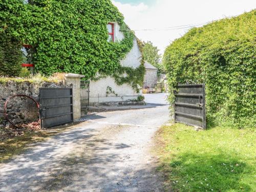 an empty road with a fence and a house at Mrs Delaney's Loft in Ardfinnan