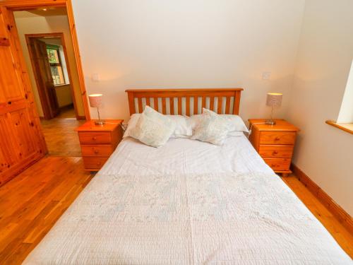 a bedroom with a large bed with two night stands at Mary Agnes Cottage in Eyeries