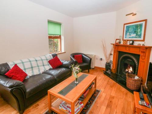 a living room with a couch and a fireplace at Mary Agnes Cottage in Eyeries