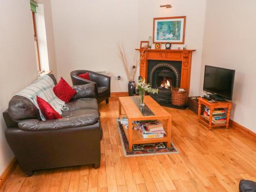 a living room with a couch and a fireplace at Mary Agnes Cottage in Eyeries