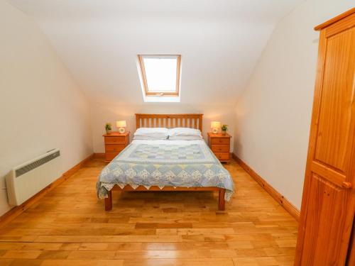 a bedroom with a bed and two night stands at Mary Agnes Cottage in Eyeries