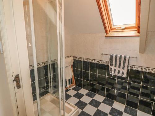 a bathroom with a shower and black and white tiles at Nana's House in Eyeries