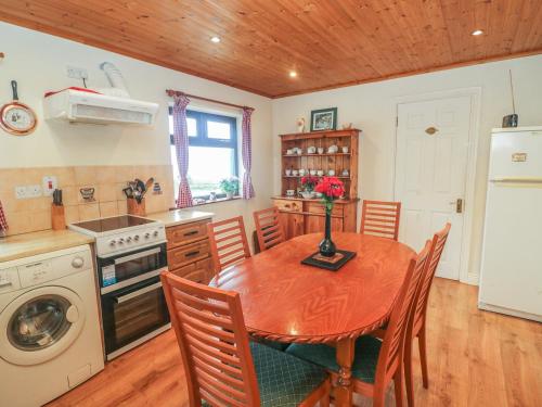 a kitchen with a wooden table and a wooden ceiling at Nana's House in Eyeries