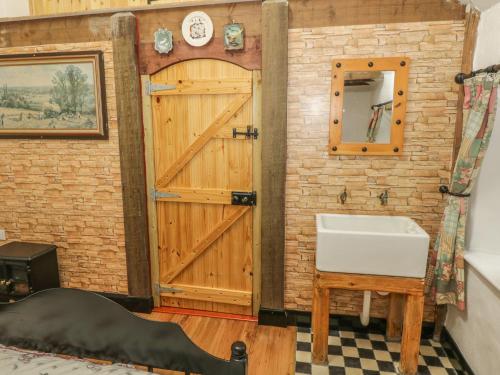 a bathroom with a wooden door and a sink at Willowbrook Cottage in Ballyshannon