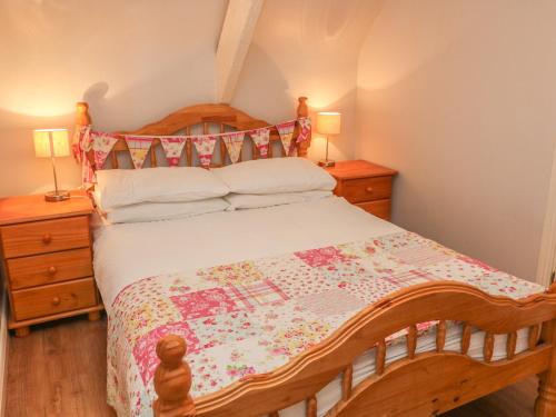 a bedroom with a wooden bed with a quilt on it at Nana's House in Eyeries