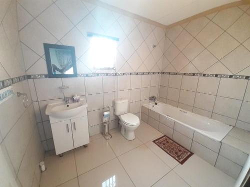 a bathroom with a toilet and a tub and a sink at KPK LODGE mankweng turfloop in Ga-Mothiba