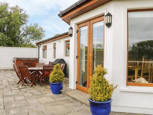 a house with two blue potted plants on a patio at 1 Ard Carraig in Portsalon