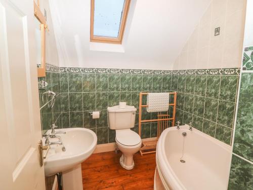 uma casa de banho com um WC, um lavatório e uma banheira em Seagaze em Youghal