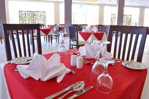 a red table with napkins and wine glasses on it at Parrotel Lagoon Waterpark Resort in Sharm El Sheikh