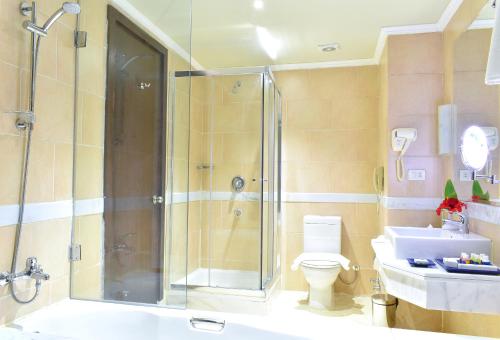 a bathroom with a shower and a toilet and a sink at Parrotel Lagoon Waterpark Resort in Sharm El Sheikh