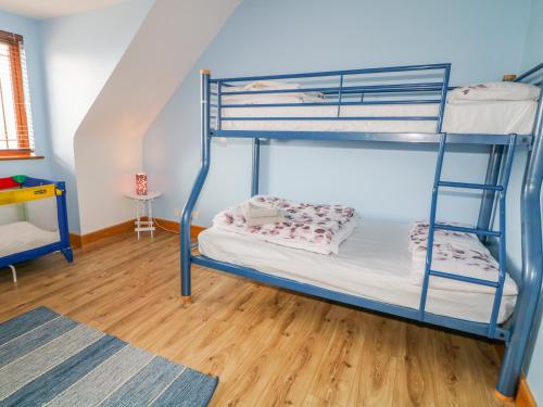 a bunk bed room with two bunk beds and a wooden floor at Mulroy View in Burnfoot