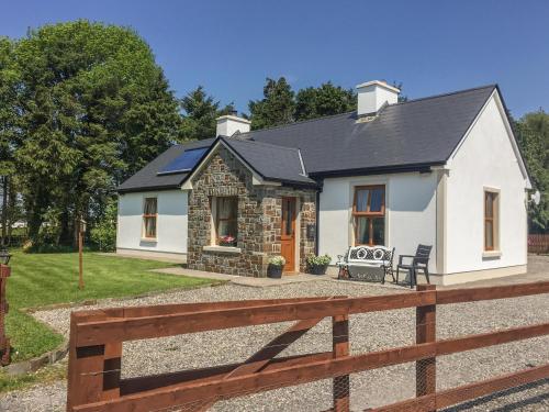 a white house with a fence in front of it at Cloonkee Cottage in Crossmolina