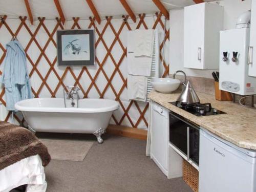 a bathroom with a tub and a sink and a stove at The Lakeside Yurt in Tewkesbury