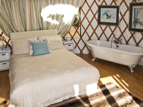 una camera con letto e vasca da bagno di The Lakeside Yurt a Tewkesbury