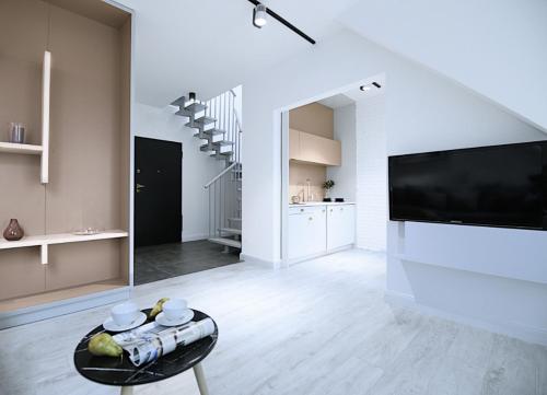 a white living room with a tv and a table at Absyntapart - Bulwar Staromiejski in Wrocław