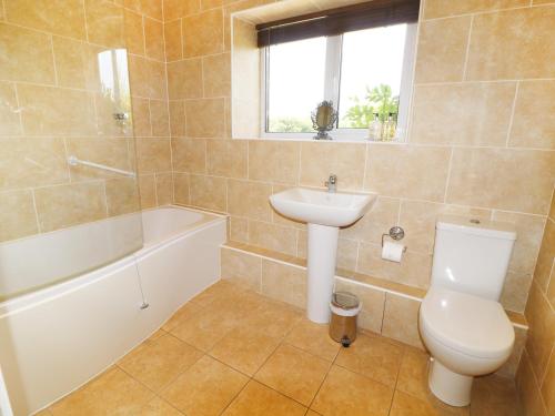 a bathroom with a sink and a toilet and a bath tub at Leigh Holt in Shepton Mallet