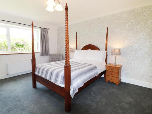 - une chambre avec un lit à baldaquin et une fenêtre dans l'établissement Leigh Holt, à Shepton Mallet