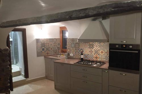 uma cozinha com fogão forno ao lado de um lavatório em Casa dei Rossi em Badalucco