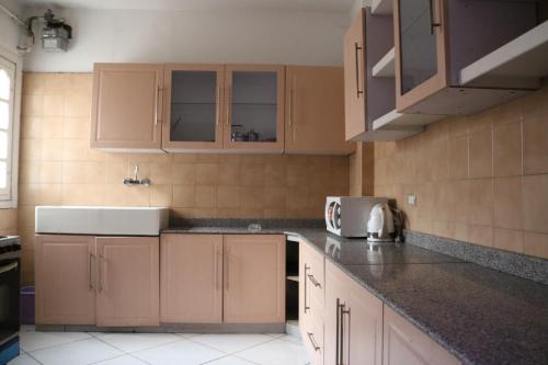 a kitchen with wooden cabinets and a counter top at Apartment at Milsa Nasr City, Building No. 35 in Cairo