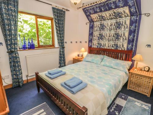 ブライナイ・フェスティニオグにある2 Waterloo Cottageのベッドルーム1室(青い枕のベッド1台付)