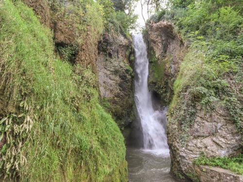 a waterfall in the middle of a rocky cliff at Riverlea in Rhyl