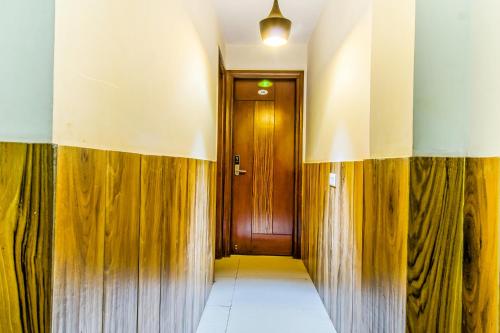 a hallway with wood paneling and a wooden door at Royal Comfort Castle in New Delhi