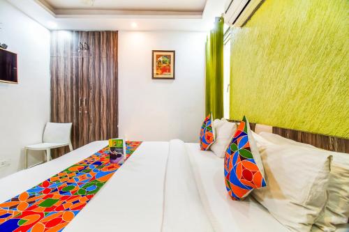 a bedroom with a white bed with colorful pillows at Royal Comfort Castle in New Delhi