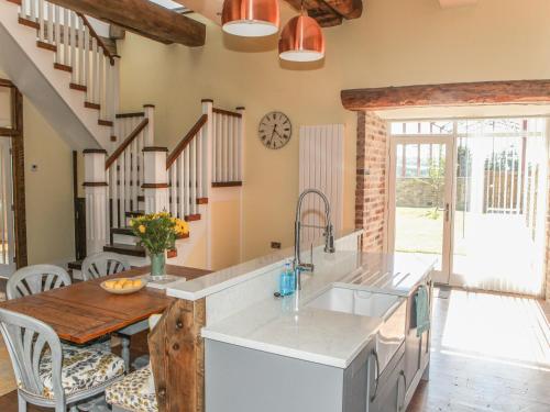 a kitchen with a sink and a table with chairs at The Granary in Durham