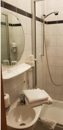 a bathroom with a sink and a shower with a mirror at Gasthof Frankenstuben in Ebern