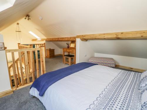 um quarto com uma cama grande e uma escada em The Hayloft em Husthwaite