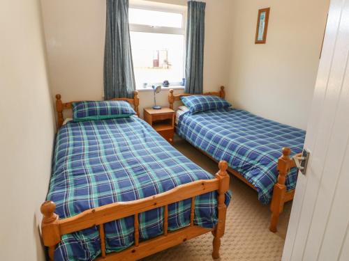 a bedroom with two beds and a window at Surf in Hunstanton