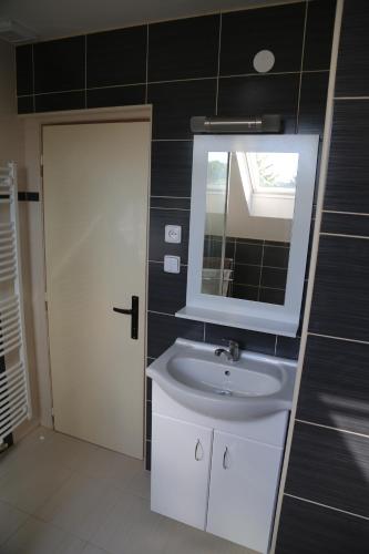 a bathroom with a white sink and a mirror at Cottage Near The Forest in Kovač