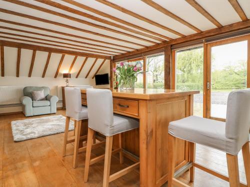 a home office with a wooden desk and white chairs at Harbourne Oast in Tenterden