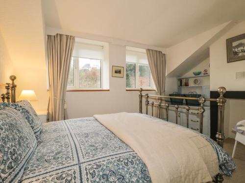 a bedroom with a bed and two windows at Derwent Edge in Portinscale