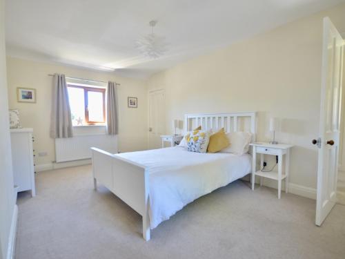 una camera da letto bianca con un letto bianco e una finestra di Ling Fell Cottage a Ulverston
