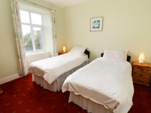 dwa łóżka w pokoju z oknem w obiekcie Low Skelgill w mieście Windermere