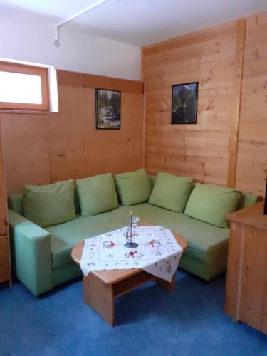 a living room with a green couch and a table at Landhaus-Königsberg, Vorberg 360 Ebengütlweg in Ramsau am Dachstein