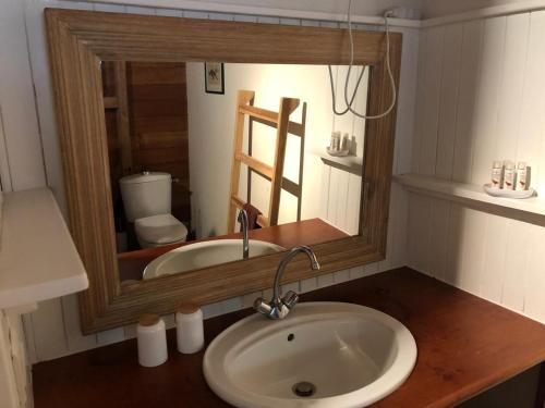 a bathroom with a sink and a mirror at Villa et Gites Le Safran - Le Triskell in Deshaies