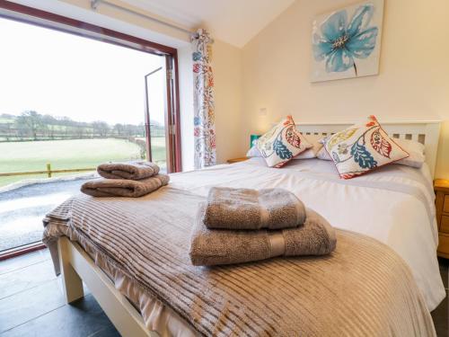 two beds with towels on them in a room with a window at Bothi in Bala
