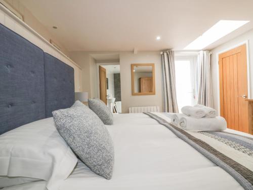 a bedroom with a large white bed with pillows at The Bolthole in Crantock