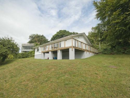 a house on a grassy field with a building at The Meadow in Feock