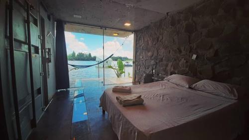 a bedroom with a bed and a stone wall at La Wayaba in Hernandarias