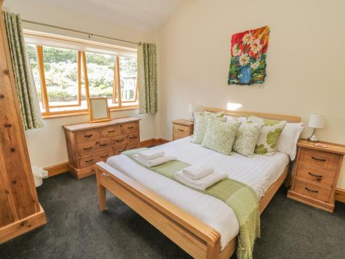 a bedroom with a large bed in a room with windows at Little Byre Cottage in Sutton