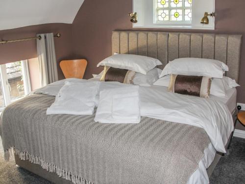 a large bed with white sheets and pillows at The Little Flat in Barnard Castle